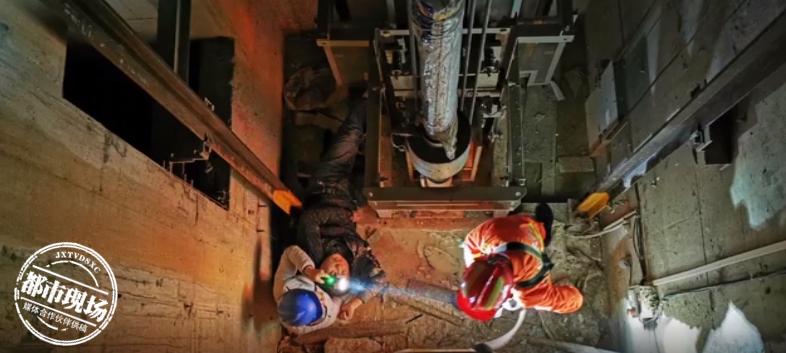 男子乘电梯意外电梯门打开后掉落,男子爬到电梯顶上电梯突然启动