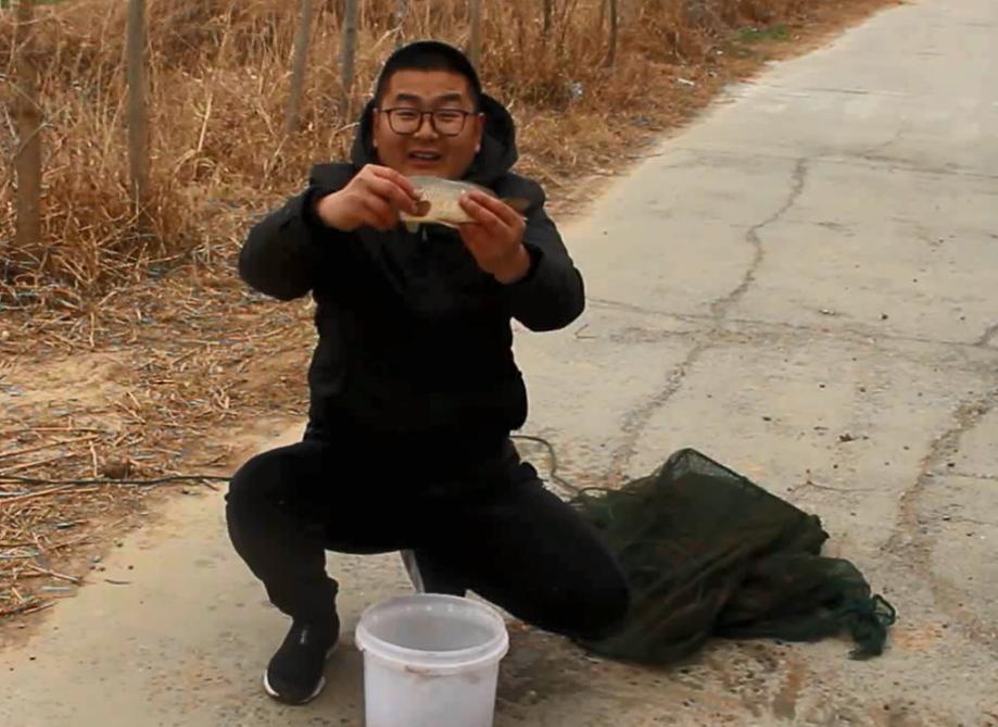 农村小伙在河里抓到一只小鱼,农村小伙河中发现废弃地笼